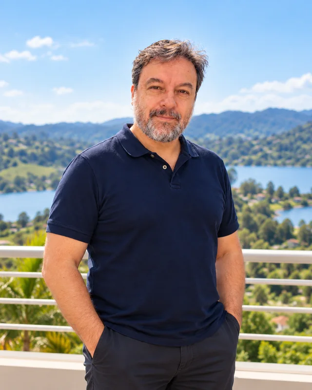 Edmar Daniel de polo azul-marinho e mãos nos bolsos, com a represa ao fundo